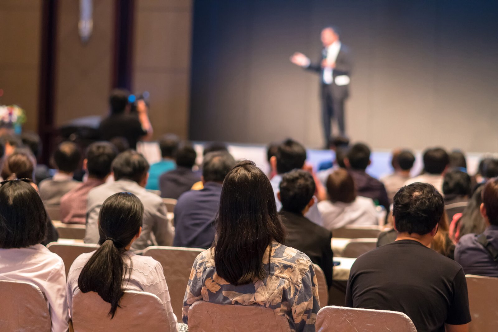 rear-side-audiences-sitting-listening-speackers-stage-scaled
